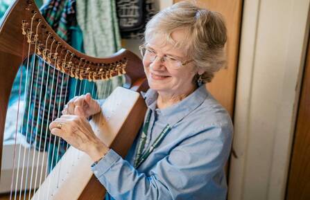 Therapeutic harp practitioner Margaret Stephens playing the harp