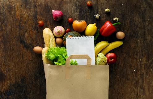 Healthy food spilling out of a paper grocery bag