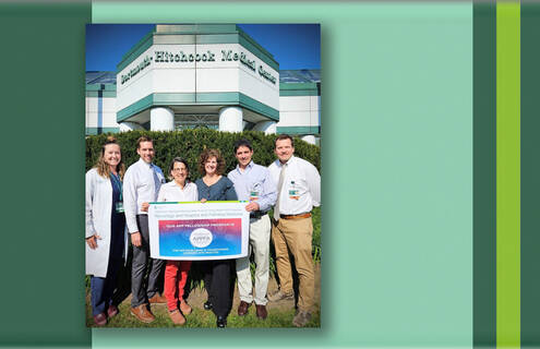 Neurology staff pose with an award certificate outside DHMC.