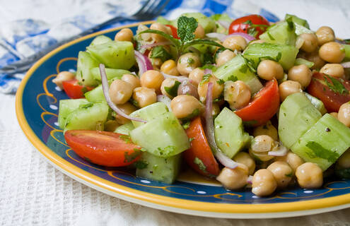 picture of a bowl of chickpea salad with cucumbers and tomatoes