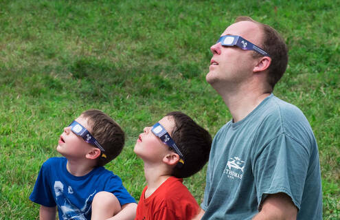 Family looking at solar eclipse