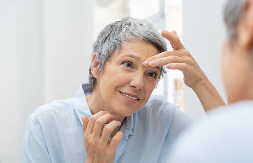 Older woman looking in mirror