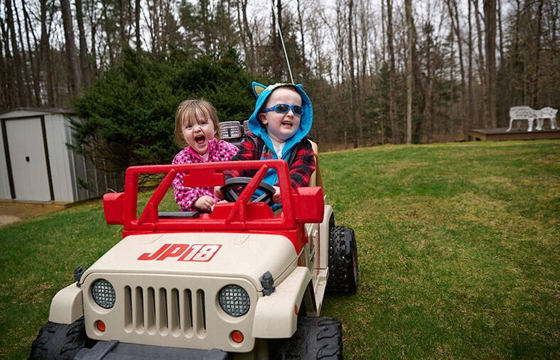 Connor Ponce and his sister enjoying a ride in their toy car